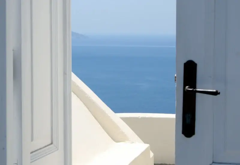 An open door with the ocean in the background